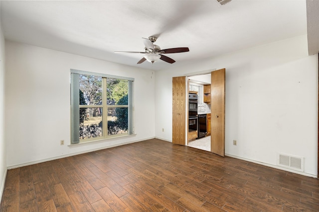 unfurnished room featuring ceiling fan and dark wood-type flooring