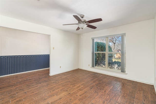 empty room with ceiling fan and dark hardwood / wood-style flooring