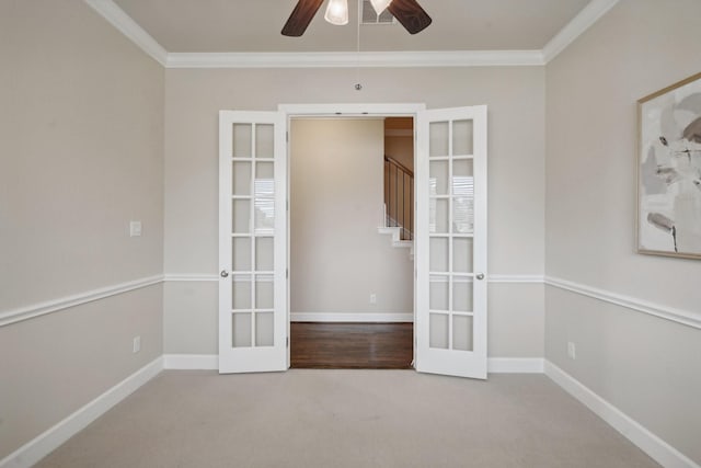 carpeted empty room with ceiling fan, ornamental molding, and french doors