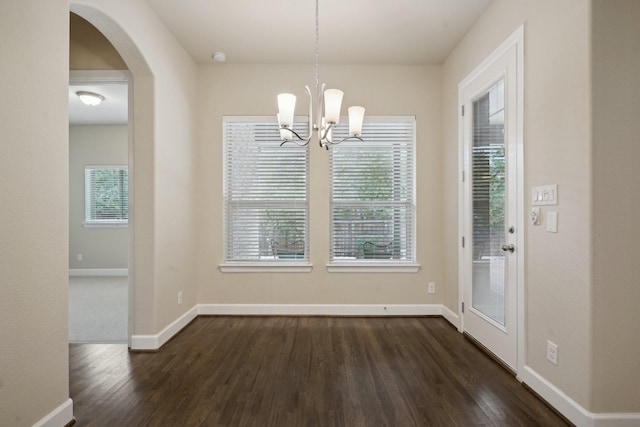 unfurnished dining area featuring dark hardwood / wood-style floors and a notable chandelier