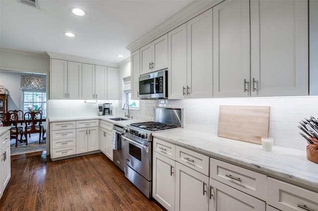 kitchen featuring sink, white cabinetry, stainless steel appliances, tasteful backsplash, and dark hardwood / wood-style flooring