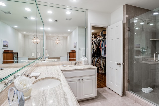 bathroom featuring walk in shower, vanity, and tile patterned flooring