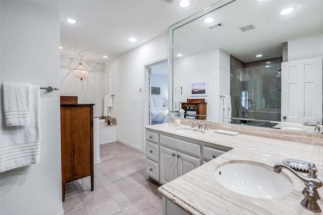 bathroom with a shower with door, vanity, and tile patterned floors