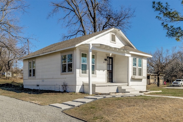 bungalow with covered porch and a front yard