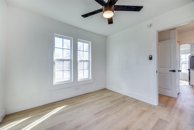 unfurnished room with ceiling fan, plenty of natural light, and light wood-type flooring