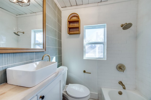 full bathroom featuring toilet, tiled shower / bath, and vanity