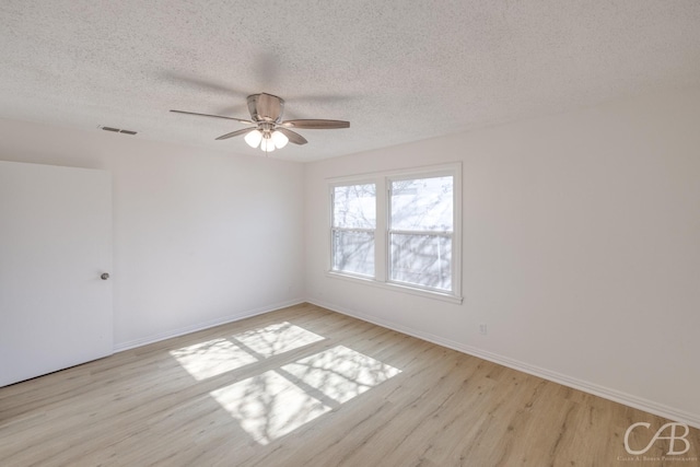 unfurnished room with ceiling fan, a textured ceiling, and light wood-type flooring