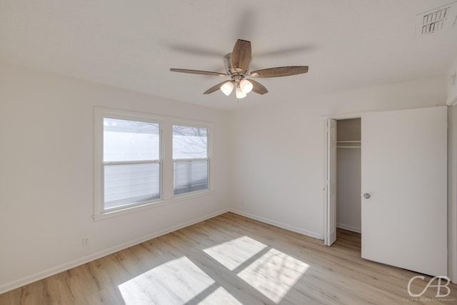 unfurnished bedroom featuring ceiling fan, light hardwood / wood-style floors, and a closet