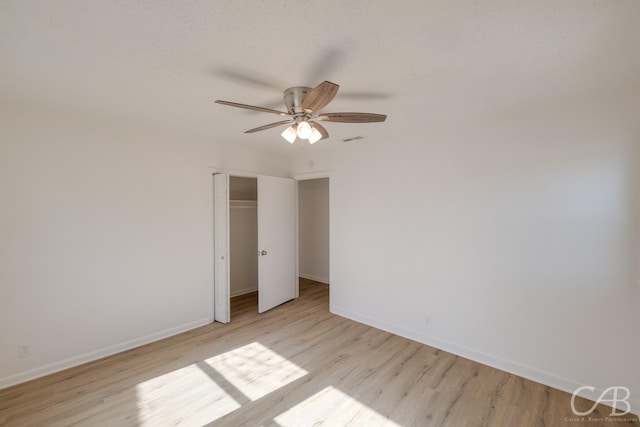 unfurnished bedroom featuring light hardwood / wood-style flooring, a closet, and ceiling fan