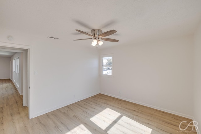 unfurnished room with ceiling fan, light hardwood / wood-style flooring, and a textured ceiling