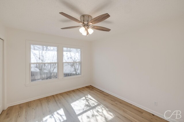 unfurnished bedroom featuring light hardwood / wood-style flooring, a textured ceiling, ceiling fan, and a closet