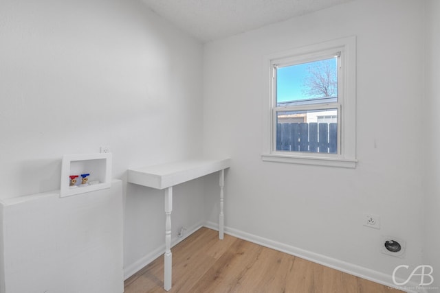 clothes washing area with hookup for a washing machine, electric dryer hookup, and light hardwood / wood-style floors