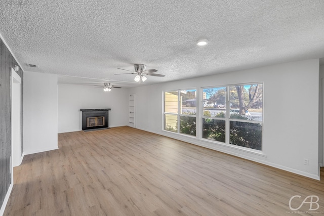 unfurnished living room with ceiling fan, light hardwood / wood-style floors, and a textured ceiling