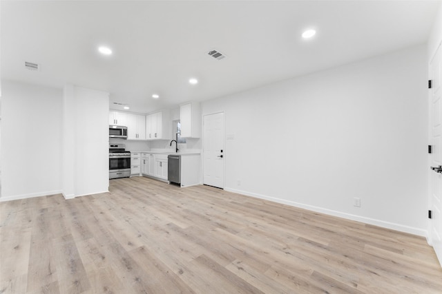 unfurnished living room with light wood finished floors, visible vents, and recessed lighting