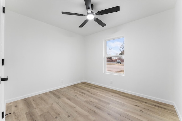 empty room featuring light wood-style flooring, baseboards, and a ceiling fan