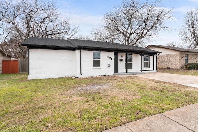 ranch-style house with a front yard, brick siding, fence, and driveway