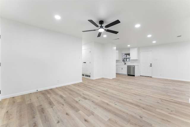 unfurnished living room with sink, light wood-type flooring, and ceiling fan