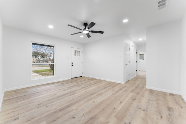 spare room with visible vents, light wood finished floors, attic access, and recessed lighting