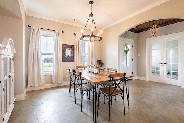 dining space with ornamental molding, concrete flooring, a notable chandelier, and french doors