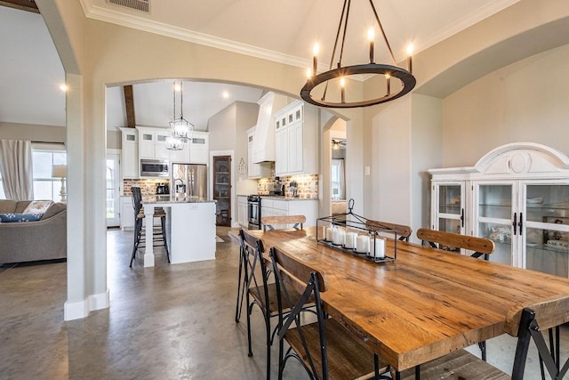 dining room with ornamental molding and a notable chandelier