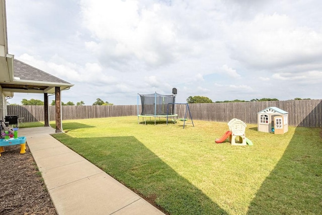 view of yard with a playground and a trampoline