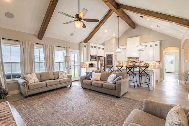 living room with beam ceiling, high vaulted ceiling, and ceiling fan