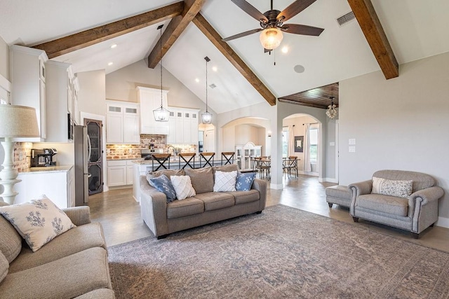 living room featuring high vaulted ceiling, beamed ceiling, and ceiling fan