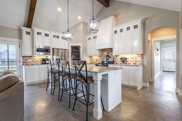 kitchen featuring a center island with sink, white cabinetry, beam ceiling, and stainless steel appliances