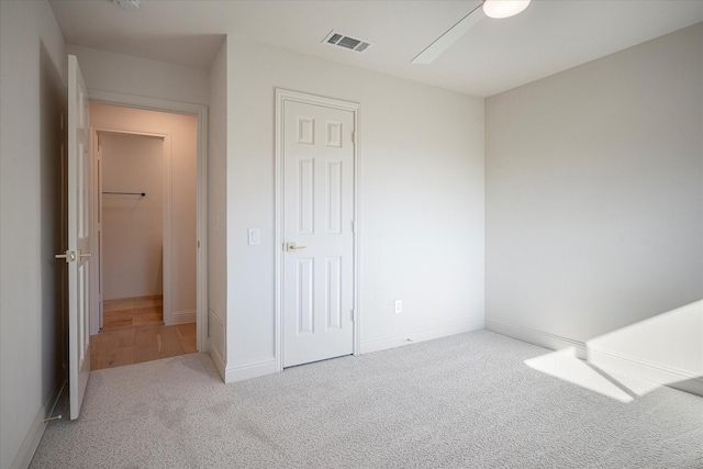 unfurnished bedroom with ceiling fan, a closet, and light carpet