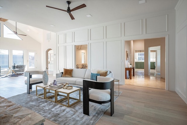 living room with high vaulted ceiling, light hardwood / wood-style floors, and ceiling fan