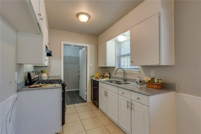 kitchen featuring a textured ceiling, white cabinetry, light tile patterned floors, sink, and stainless steel range with gas stovetop