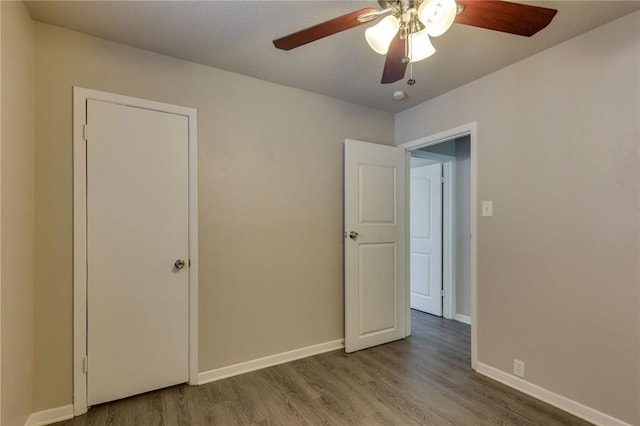 unfurnished bedroom with ceiling fan and wood-type flooring