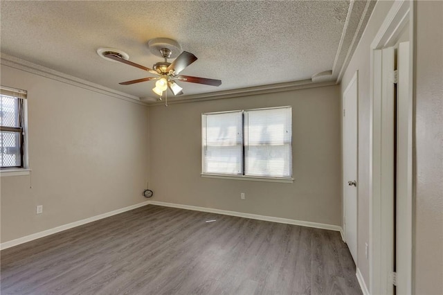 empty room with hardwood / wood-style floors, a textured ceiling, ceiling fan, and ornamental molding