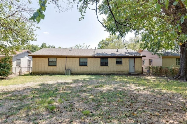 rear view of property featuring central AC unit and a yard