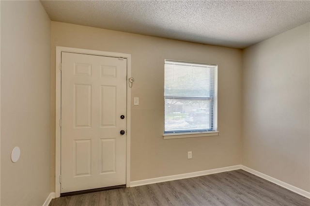 entryway with hardwood / wood-style floors and a textured ceiling