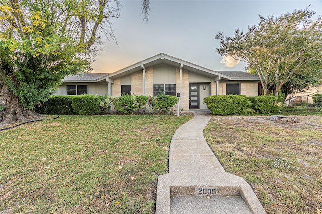 ranch-style home featuring a lawn