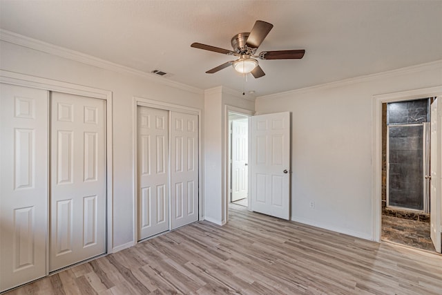 unfurnished bedroom featuring multiple closets, light wood-type flooring, ceiling fan, and ornamental molding