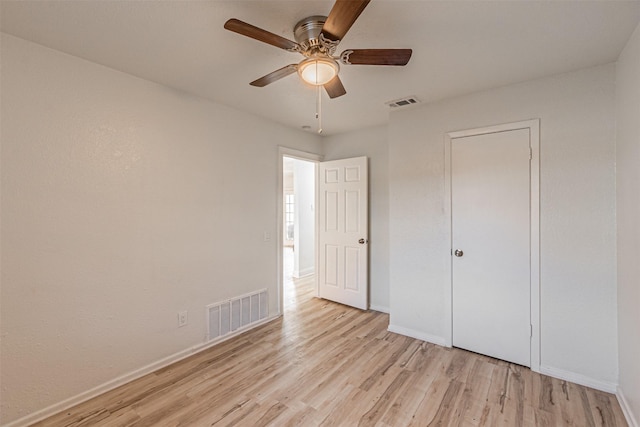 unfurnished bedroom with ceiling fan, light hardwood / wood-style flooring, and a closet