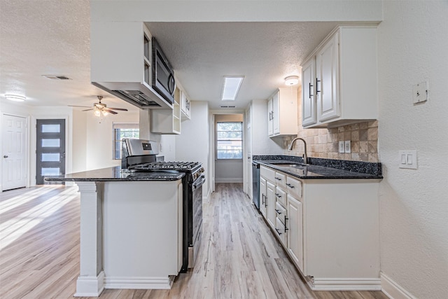 kitchen featuring kitchen peninsula, sink, white cabinetry, a wealth of natural light, and stainless steel appliances