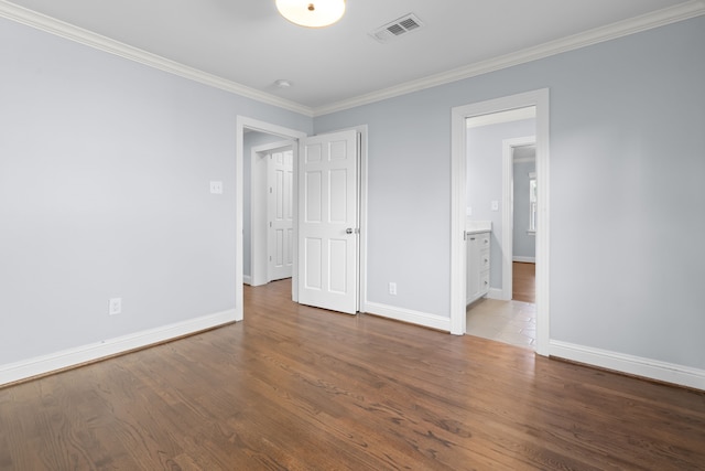 unfurnished bedroom with hardwood / wood-style flooring, connected bathroom, and ornamental molding