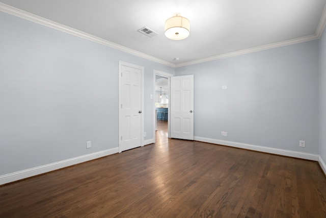 spare room featuring dark hardwood / wood-style floors and crown molding