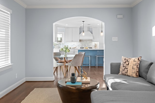 living room with a wealth of natural light, crown molding, and dark wood-type flooring