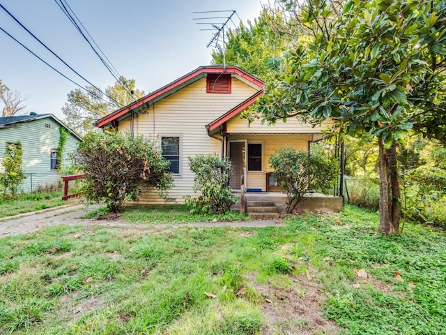 bungalow-style house featuring a front lawn