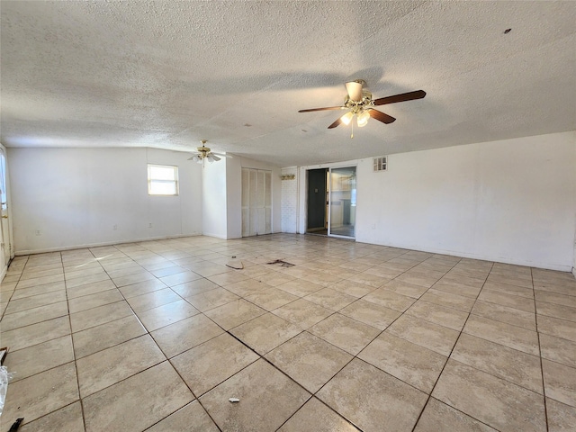 empty room featuring ceiling fan, a textured ceiling, and light tile patterned flooring