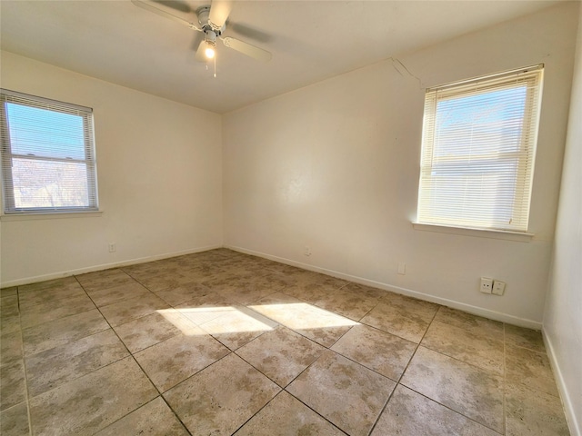 spare room with ceiling fan and light tile patterned floors