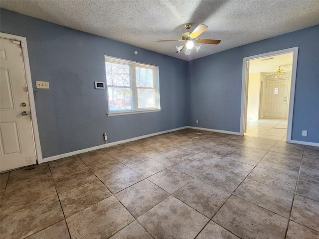 tiled spare room featuring a textured ceiling and ceiling fan