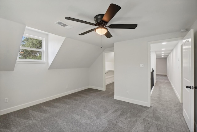 bonus room with light colored carpet and vaulted ceiling