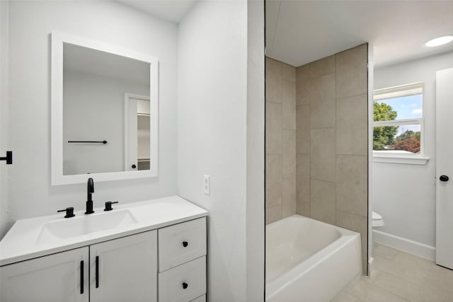 full bathroom with tiled shower / bath combo, toilet, tile patterned floors, and vanity