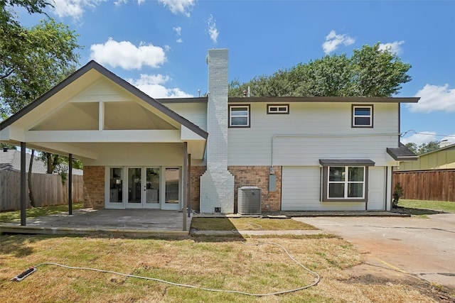 rear view of property featuring french doors, a patio, central AC unit, and a lawn