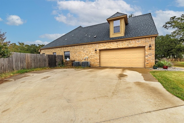 exterior space with a garage and central AC